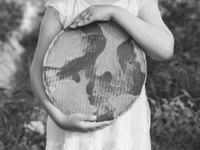child holding up a painted carton in the shape of the earth